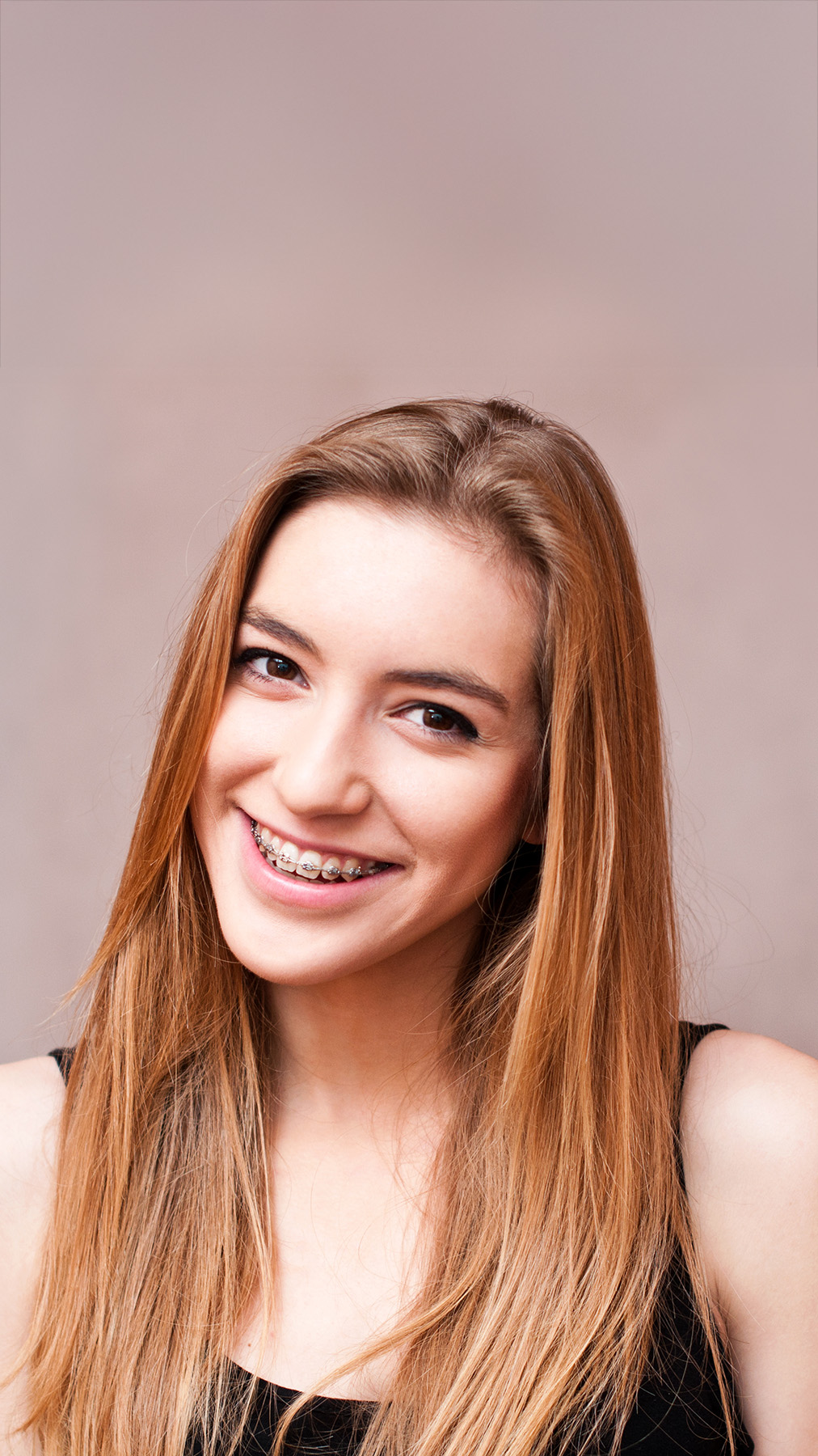A young woman with long hair smiling at the camera.
