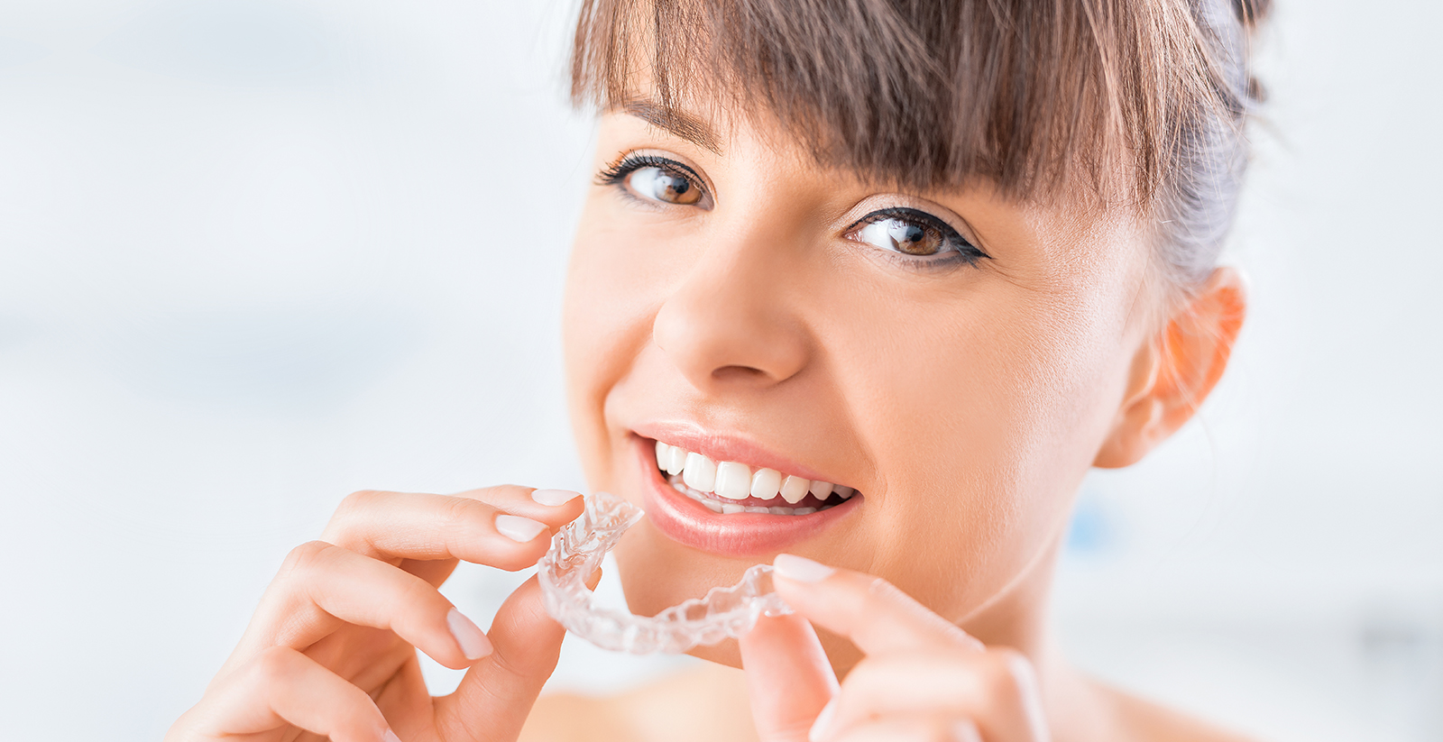 Woman brushing her teeth with toothpaste in her mouth.